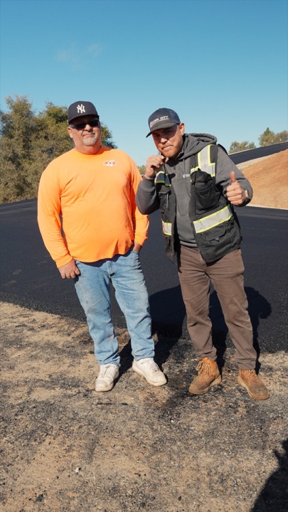 Two crew members on a freshly paved lot